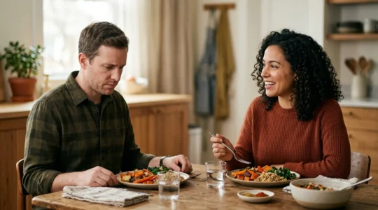 Two individuals at a dining table illustrating contrasting digestive experiences with wholesome meals
