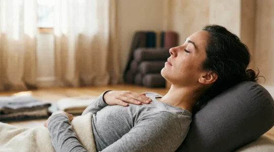 A person experiencing emotional release during a supported restorative yoga pose, showing vulnerability and nervous system safety