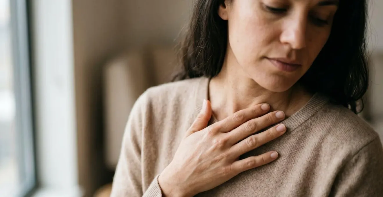 A human hand gently pressed against a bare collarbone in natural light, representing the practice of listening to somatic feedback and body wisdom