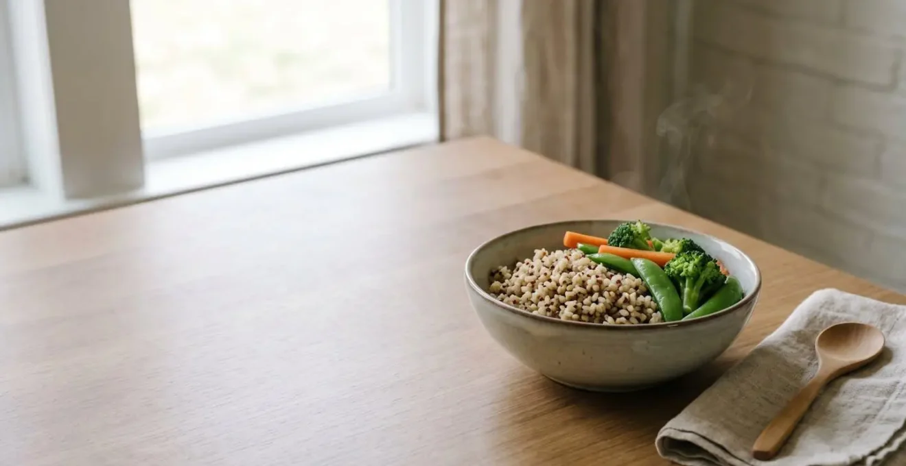 A simple bowl of warm cooked whole grains and vegetables in soft natural lighting suggesting digestive ease and nourishment